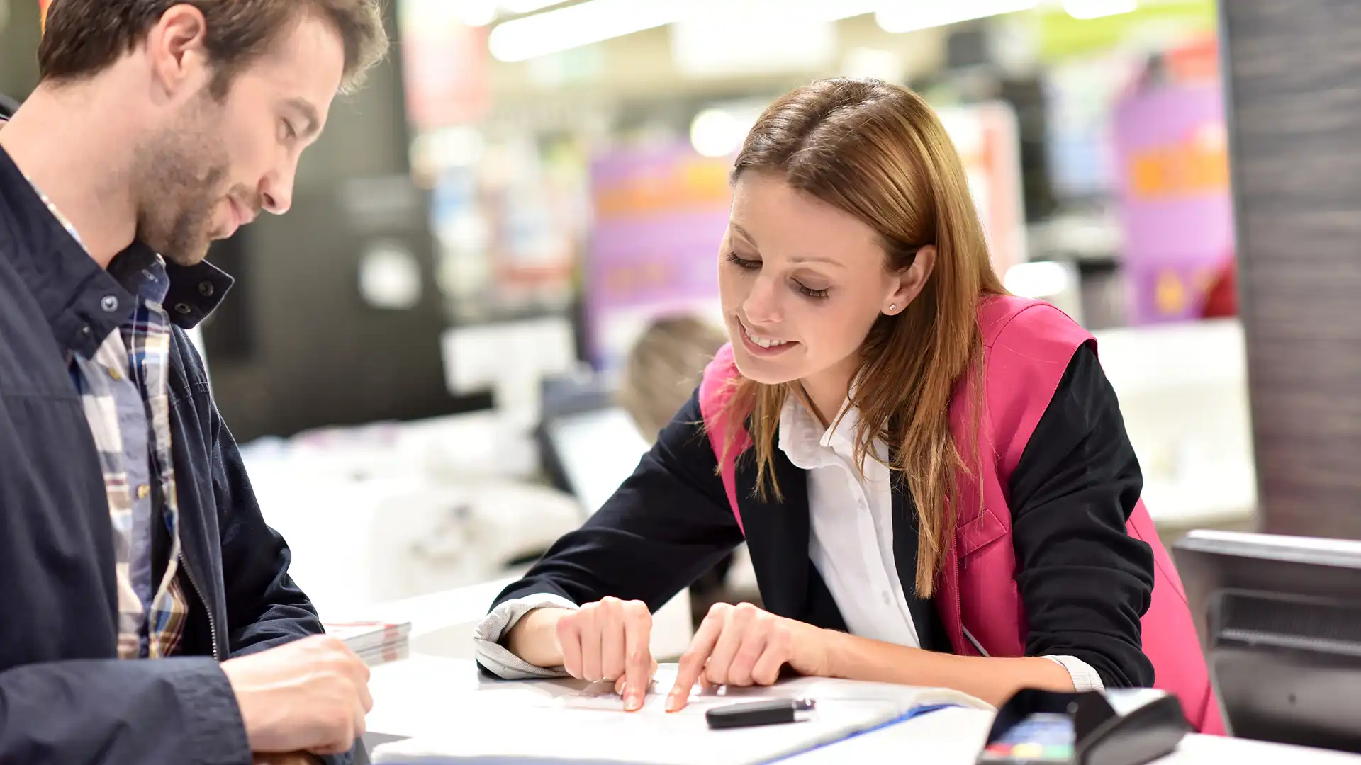 Automotive professional reviewing paperwork with a dealership team member