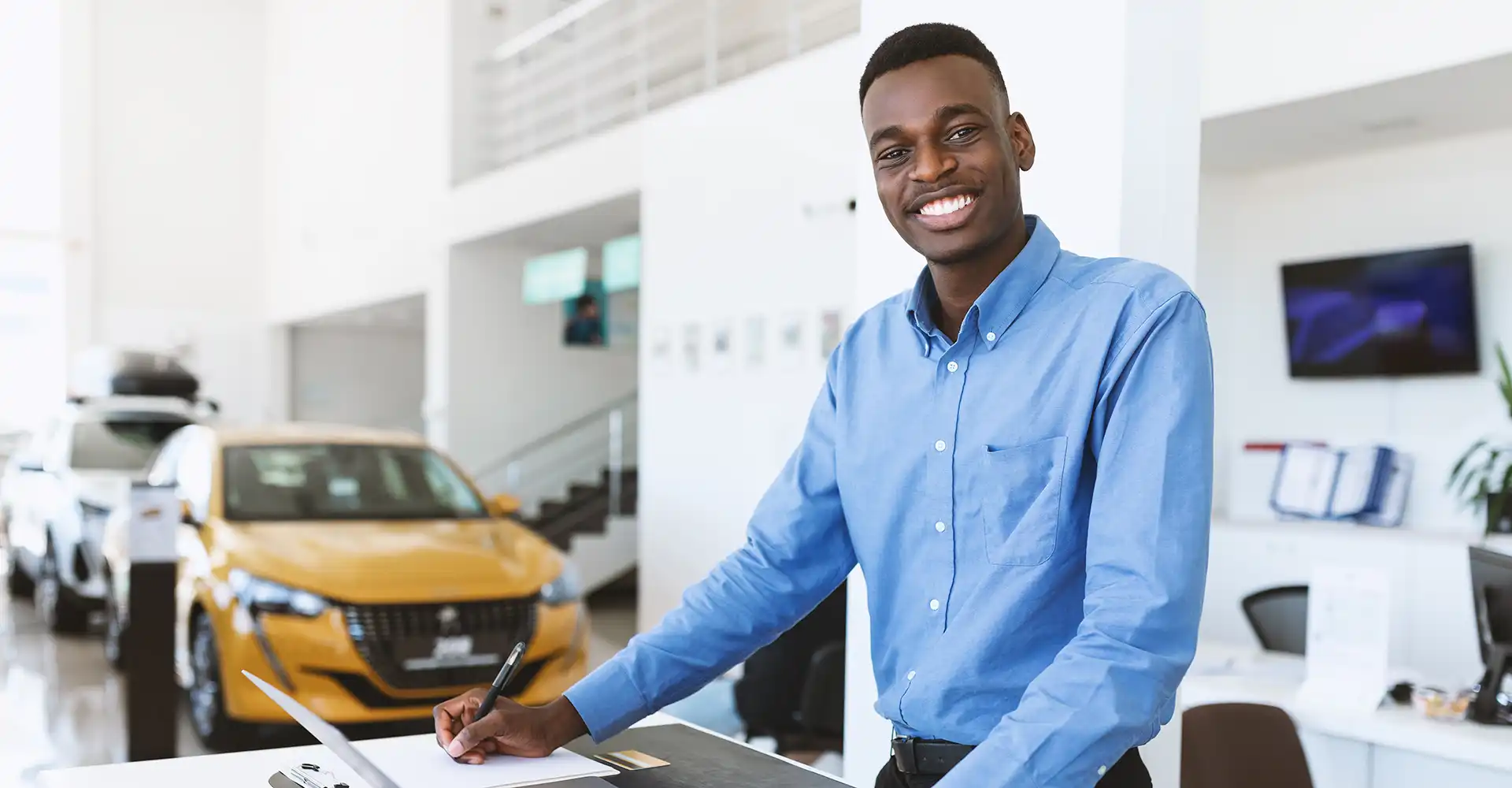 Smiling dealership service advisor at a desk